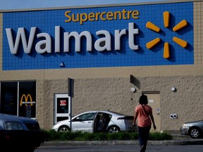 Customers walk toward the entrance of the LaSalle Walmart in Montreal on Wednesday June 17, 2015. Quebec will oblige Quebec retailers to add French descriptives to their outdoor banners, the minister responsible for the French Language Charter said Wednesday.