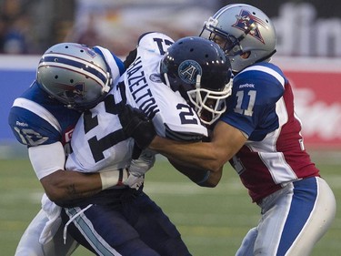 Montreal Alouettes Chip Cox, right, and Geoff Tisdale, bring down Toronto Argonauts Vidal Hazelton, during pre-season CFL football action in Montreal on Thursday June 18, 2015.