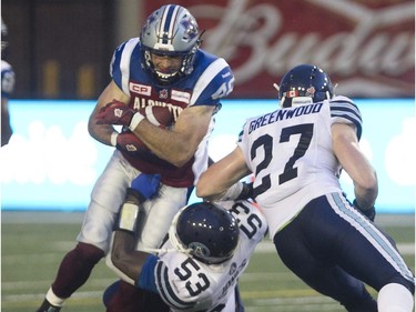 Montreal Alouettes Jean-Christophe Beaulieu, makes his way past  Toronto Argonauts Gregory Jones, centre, and Cory Greenwood, right, during pre-season CFL football action in Montreal on Thursday June 18, 2015.