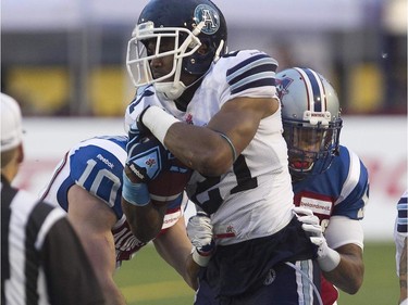 Montreal Alouettes Marc-Olivier Brouillette, left, and Geoff Tisdale,  tackle Toronto Argonauts Vidal Hazelton, during pre-season CFL football action in Montreal on Thursday June 18, 2015.