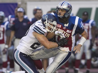 Montreal Alouettes quarterback Jonathan Crompton is brought down on hit by Cory Greenwood of the Toronto Argonauts during pre-season CFL football action in Montreal on Thursday June 18, 2015.