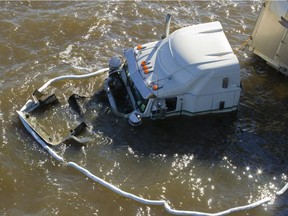 A transport truck sits in Deux-Montagnes Lake after it went off the Île aux Tourtes Bridge on highway 40 westbound.