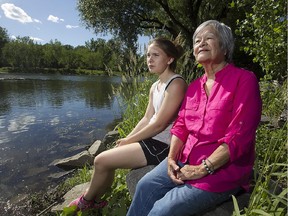 Maris Jacobs, left, and Kakaionstha Deer stand by the waters edge at the Onake Paddling Club, in Kahnawake on Friday June 19, 2015. They are part of The Foundation for the Compulsory Study, a Montreal-based organization that is working to urge the province to include genocide studies, including residential schools, in high school curriculum.