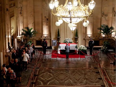 A member of the public pays his respects to Jean Doré as he lies in state in the Hall of Honour at Montreal city hall on Sunday June 21, 2015. F