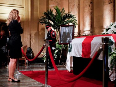 A woman says a prayer as she pays her respects to Jean Doré as he lies in state in the Hall of Honour at Montreal city hall on Sunday June 21, 2015.