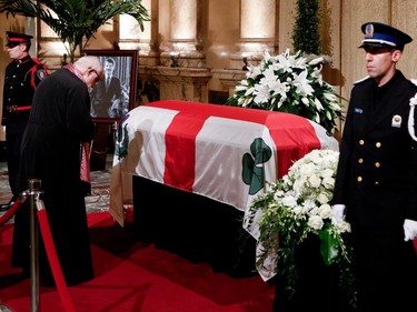 Economos Antony Gabriel of St. George Antiochian Church of Montreal pays his respects to Jean Doré as he lies in state in the Hall of Honour at Montreal city hall on Sunday June 21, 2015.