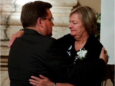 Montreal Mayor Dennis Coderre is greeted by Christian Sauvé in the Hall of Honour as former Montreal mayor Jean Doré lies in state at Montreal city hall on Sunday June 21, 2015.
