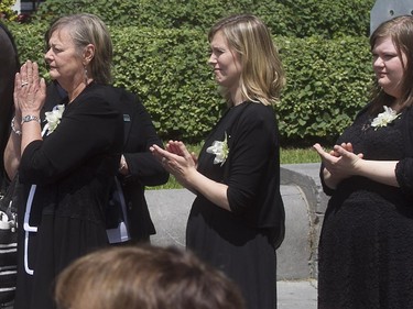 The family of former Montreal mayor Jean Doré, his wife Christiane Sauvé, left, daughters Amélie Duceppe, centre, and Magali Doré share in the applause given to Jean Doré following the service at Montreal city hall on Monday June 22, 2015.