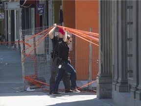 Police enter an alleyway off St-Laurent Blvd. near Clark St. and Pins Ave. in Montreal, on Wednesday, June 24.