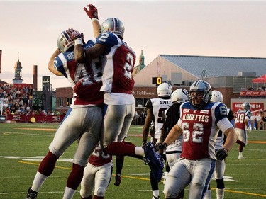 Montreal Alouettes slotback Fred Stamps and Montreal Alouettes running back Jean-Christophe Beaulieu, left, get airborne as they celebrate a touchdown against the Ottawa Redblack during CFL action at the Percival Molson Stadium in Montreal on Thursday June 25, 2015.
