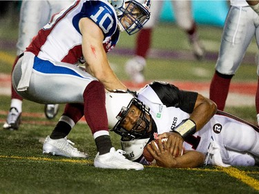 Ottawa Redblacks quarterback Henry Burris hits the turf to avoid being sacked by Montreal Alouettes safety Marc-Olivier Brouillette during CFL action at the Percival Molson Stadium in Montreal on Thursday June 25, 2015. The Redblacks beat the Alouettes 20-16.