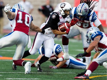 Ottawa Redblacks wide receiver Chris Williams is surround by Montreal Alouettes safety Marc-Olivier Brouillette, left to right, Montreal Alouettes linebacker Nicolas Boulay, Montreal Alouettes defensive back Dominique Ellis and Montreal Alouettes linebacker Winston Venable during CFL action at the Percival Molson Stadium in Montreal on Thursday June 25, 2015.