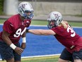 Michael Sam left, practises alongside James Tuck right, during Montreal Alouettes football practice at Parc Hebert in Montreal, on Monday, June 29, 2015.