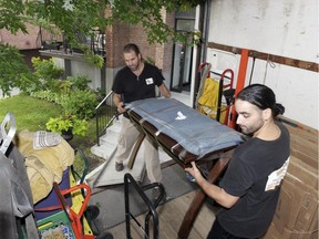 We-Haul Moving company owner Ericson Martin, centre, and Jonas Garnett pack items into their truck for transport.