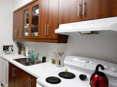 Bright white walls highlight the deep wood cupboards in the kitchen.