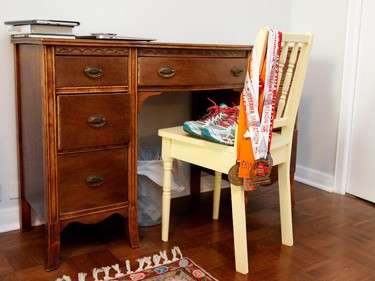 Medals from marathons hang on a chair in the bedroom.