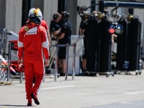 Ferrari Formula 1 driver Sebastian Vettel of Germany walks through the garages during the qualifying session for the F1 Canadian Grand Prix at Circuit Gilles-Villeneuve in Montreal on Saturday, June 6, 2015.