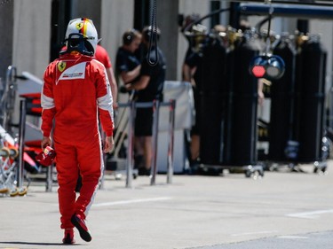 Ferrari Formula 1 driver Sebastian Vettel of Germany walks through the garages during the qualifying session for the F1 Canadian Grand Prix at Circuit Gilles-Villeneuve in Montreal on Saturday, June 6, 2015.