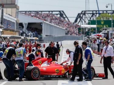 Ferrari Formula 1 driver Sebastian Vettel of Germany returns to the garage during the qualifying session for the F1 Canadian Grand Prix at Circuit Gilles-Villeneuve in Montreal on Saturday, June 6, 2015.