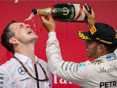 Mercedes Formula 1 driver Lewis Hamilton of Great Britain, right, pours champagne onto Mercedes race engineer Riccardo Musconi, left, after finishing first in the Canadian Grand Prix at Circuit Gilles-Villeneuve in Montreal on Sunday, June 7, 2015. Mercedes Formula 1 driver Nico Rosberg of Germany came second followed by Williams Formula 1 driver Valtteri Bottas of Finland in third place.
