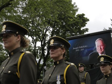 Sûreté du Québec officers line up in front of a poster of Jacques Parizeau outside the Saint-Germain d'Outremont Church in Montreal Tuesday June 9, 2015 two hours before the funeral of former Quebec Premier Jacques Parizeau.