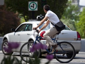 A cyclist rides on the de Maisonneuve boulevard cycling path on the corner of McGill College avenue in downtown Montreal.