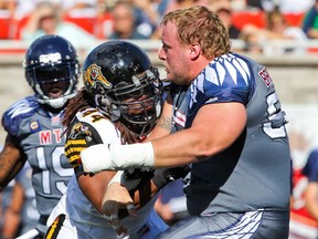 Alouettes centre Luc Brodeur-Jourdain is hit by Hamilton Tiger-Cats' Taylor Reed after losing his helmet during game in 2015.