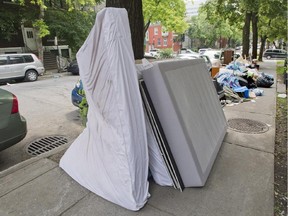 A discarded mattress and bed is shown on a street in Montreal, Monday, July 1, 2013, on what has become known as "Moving Day."