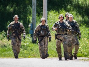 Police with the New York state tactical unit walk on Johnson road as they continue the search for escaped convicted killers Richard Matt and David Sweat in Chasm Falls, New York, 130 kilometres south-west of Montreal on Wednesday, June 24, 2015.