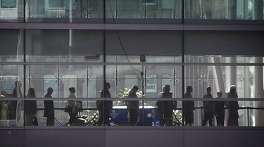 Mourners pass next to the flagged draped coffin of former Quebec premier Jacques Parizeau at the Caisse de dépôt et placement du Québec in Montreal, on Saturday June 6, 2015.