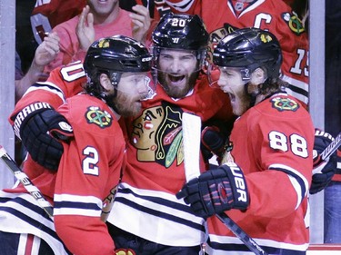 Chicago Blackhawks' Duncan Keith, left, is congratulated by teammates Brandon Saad and Patrick Kane, right, after scoring during the second period in Game 6 of the NHL hockey Stanley Cup Final series on against the Tampa Bay Lightning Monday, June 15, 2015, in Chicago.