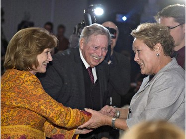 Parti Quebecois Leader Pauline Marois, right, shakes hand with Lisette Lapointe, wife of former Quebec premier Jacques Parizeau, centre, as she attends a Quebec Municipalities meeting, Friday, March 21, 2014 in Quebec City. Quebecers are going to the polls on April 7.