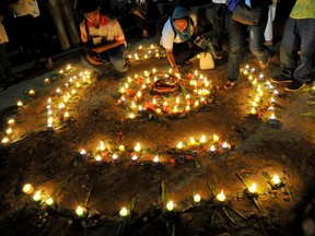 Peace advocates light candles during an interfaith prayer and candle lighting for peace at a park in Manila.
