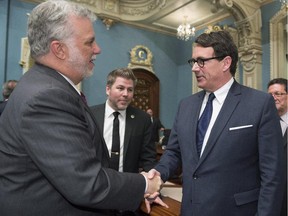 Quebec Premier Philippe Couillard, left, greets Quebec Opposition Leader Pierre Karl Péladeau as he enters the legislature for question period Tuesday, May 19, 2015 in Quebec City. Peladeau was elected as the new leader of the Parti Quebecois on Friday, May 15.