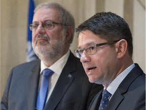 New Hydro-Québec president Éric Martel, right, speaks at a news conference on Wednesday at the  legislature in Quebec City as provincial Energy and Natural Resources Minister Pierre Arcand looks on.