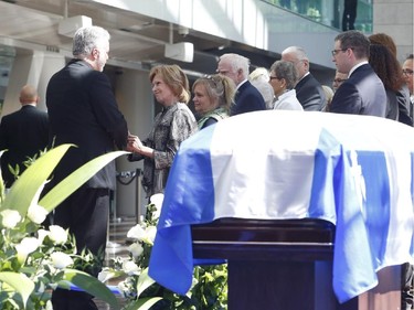 Quebec Premier Philippe Couillard gives his condolences to Lisette Lapointe, wife of former Quebec premier Jacques Parizeau, as her husband lies in state at the Caisse de dépôt et placement du Québec in Montreal on Saturday, June 6, 2015.