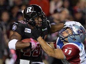 Ottawa Redblacks' Roy Finch gets tackled by Montreal Alouettes' Chip Cox during CFL action in Ottawa on Friday Oct 24, 2014.