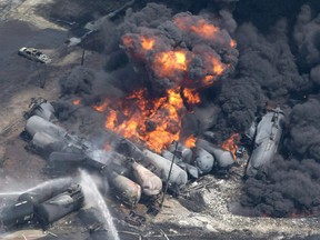 Smoke rises from railway cars that were carrying crude oil after derailing in downtown Lac-Mégantic, Que., Saturday, July 6, 2013.