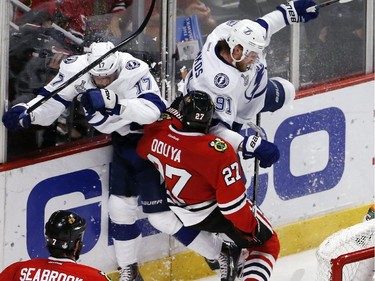 Chicago Blackhawks' Johnny Oduya (27), of Sweden, collides with Tampa Bay Lightning's Alex Killorn (17) and Steven Stamkos (91) during the second period in Game 6 of the NHL hockey Stanley Cup Final series on Monday, June 15, 2015, in Chicago.