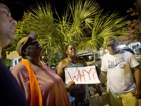 Surreace Cox, of North Charleston, S.C., holds a sign during a prayer vigil down the street from the Emanuel AME Church early Thursday, June 18, 2015, following a shooting Wednesday night in Charleston, S.C.