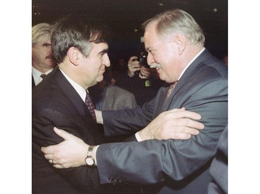 The new Quebec Premier Lucien Bouchard (L) shares a moment with the former Quebec Premier Jacques Parizeau on January 26, 1996.