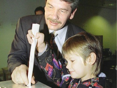 Jean Dore casts his ballot with his daughter alongside