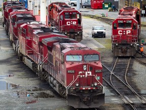 A Canadian Pacific Rail maintenance worker climbs onto a locomotive at the company's Port Coquitlam yard east of Vancouver in 2012.