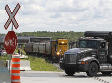A dumptruck and a train intersect at the entrance to the disaster zone in the town of Lac-Mgantic, Friday July 03, 2015.  Rehabilitation of the town centre continues two years after the train derailment and fire that destoyed it and killed 47 residents.