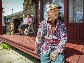 Fernand Champagne, 84, takes a break from mowing his lawn on Lafontaine St. in the town of Lac-Mégantic on Friday, July 3, 2015 as his wife Helene sits on the porch watching.