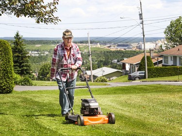 Fernand Champagne, 84 years old, mows his lawn on Lafontaine St. in the town of Lac-Mgantic, Friday July 03, 2015.