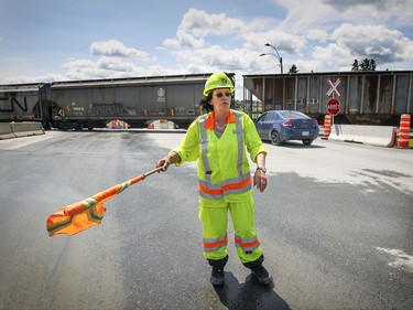 Diane Duquette directs traffic around the disaster zone as a freight train passes through the town of Lac-Mgantic, Friday July 03, 2015.