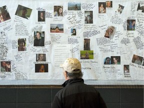 A man looks at photos of some of the victims of the devastating fire in Lac-Mégantic as part of commemorative events marking the first anniversary in 2014 in Lac-Mégantic, Que.