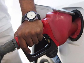 A person pumps fuel. Gasoline prices rose overnight.
