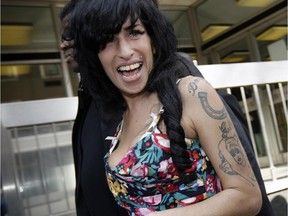 In this file photo dated Tuesday, March 17, 2009, British Singer Amy Winehouse leaves the City of Westminster Magistrates Court in west London,  where she faces a charge of common assault over an incident at a charity ball.  A new movie entitled "Amy" directed by Asif Kapadia, is scheduled for release on Friday July 3, 2015. Critics love the movie and top performers sing the praises of the late Amy Winehouse, but the singer's father, Mitch Winehouse, says the film has been edited to depict the family as doing too little to help the ephemeral Amy Winehouse overcome addiction.